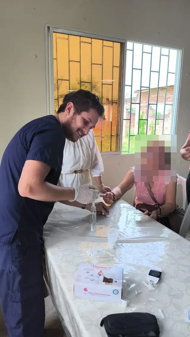 Un médico de CrabCare toma una muestra de sangre capilar a una paciente en su casa