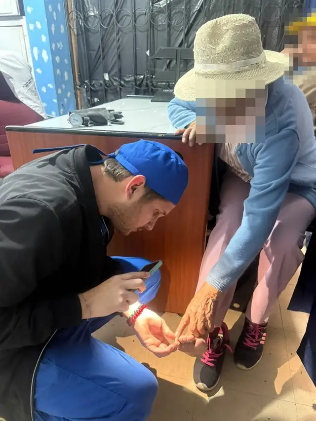 Un médico de CrabCare examina el pie de una paciente adulta mayor, que le señala dónde le duele
